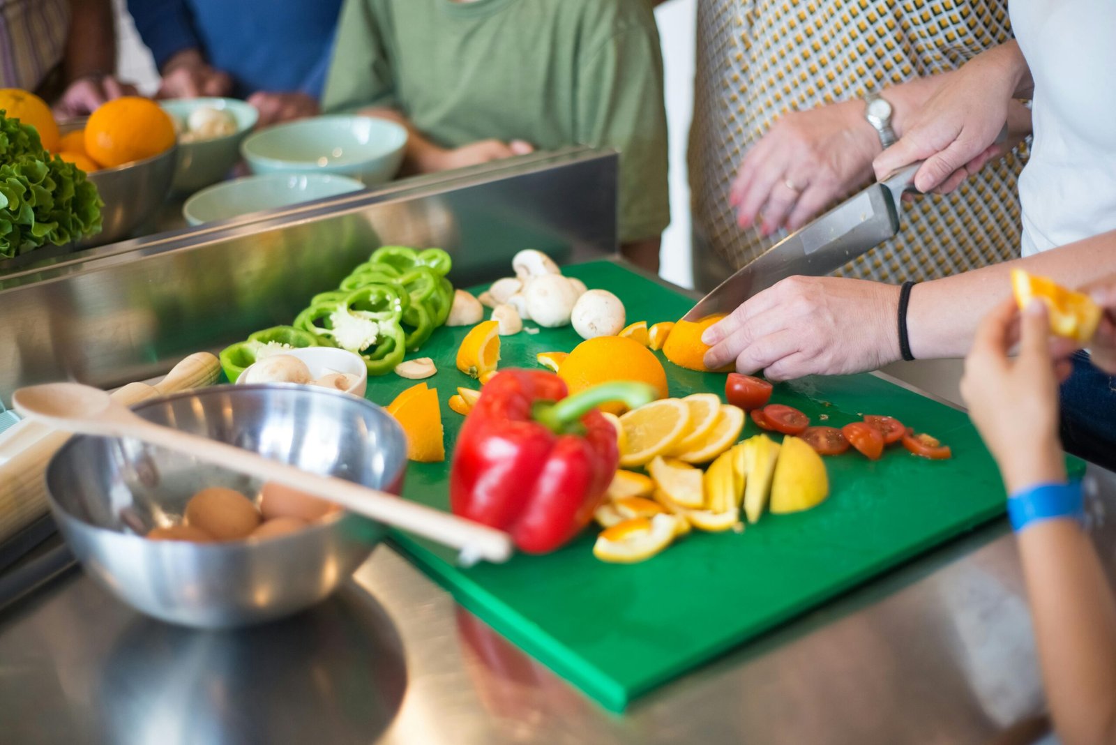A family enjoying cooking together indoors with fresh fruits and vegetables.
